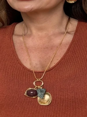 COLAR LONGO DOURADO COM PINGENTES PEDRA VINHO, PEDRA BRUTA E MEDALHA