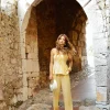 “regata angel kaele amarela com brilho sutil” “regata feminina com alças finas e peplum delicado” “detalhe do tecido acetinado e acabamento elegante”
